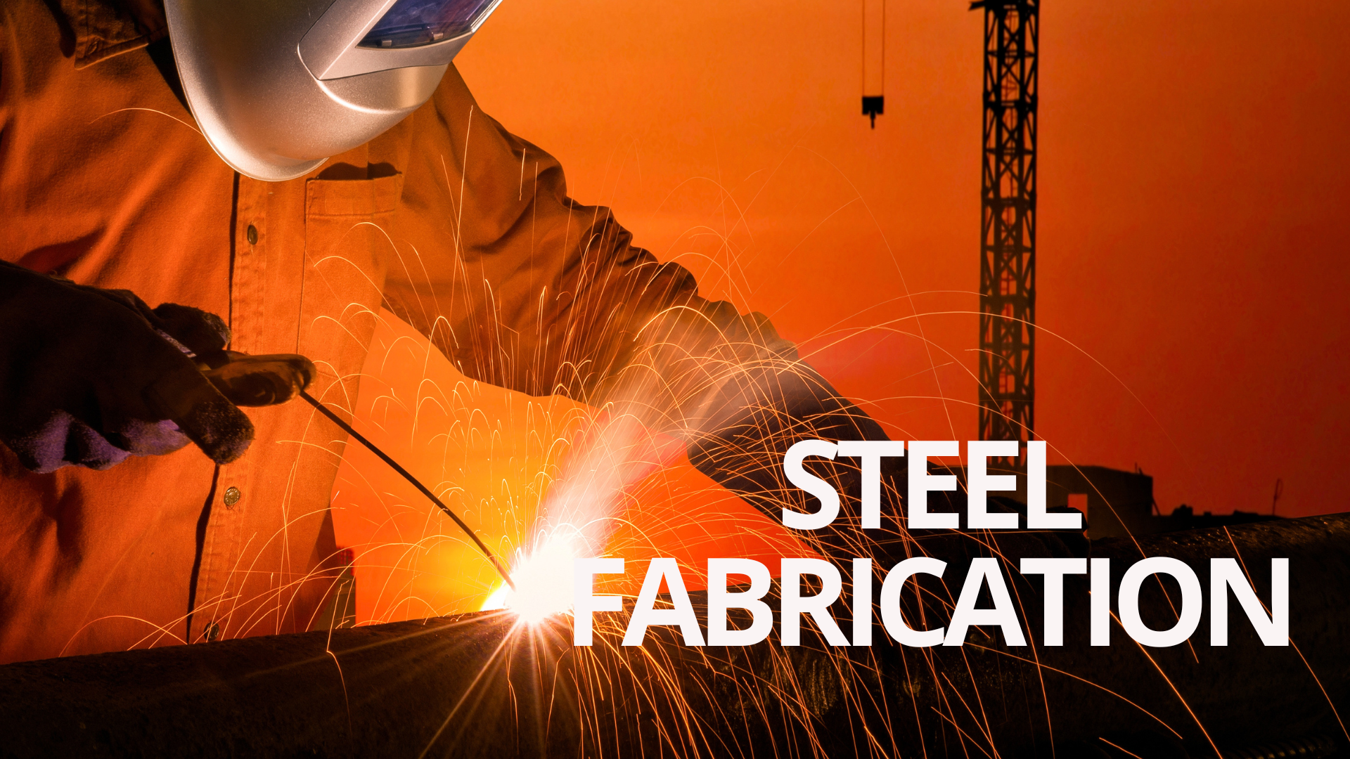 Welder performing steel fabrication at construction site with sparks flying and crane in the background